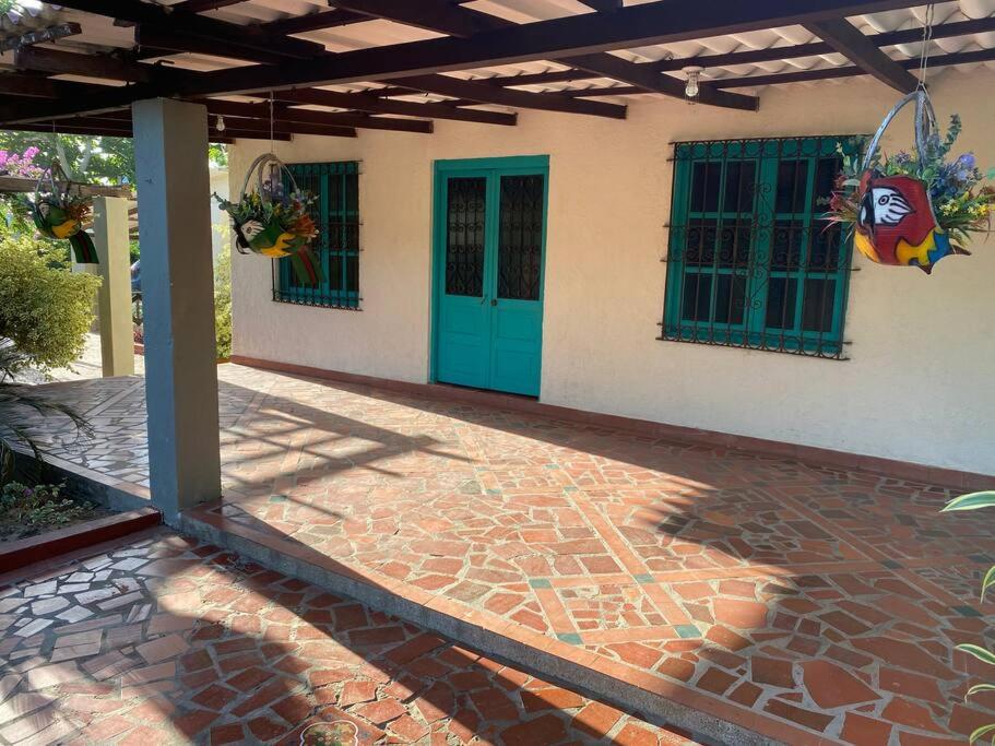 a house with a green door and a brick patio at Casa campestre San José - Descansa y Diviértete in Santo Tomás