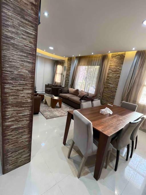 a living room with a wooden table and chairs at 3 bedrooms flat,fully equipped in Cairo