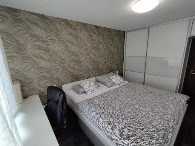 1 dormitorio con cama y pared en Prievidza Home, en Prievidza