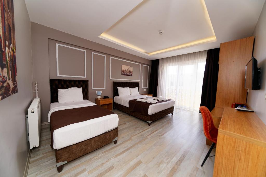 a hotel room with two beds and a television at HanPoint Boutique Hotel in Istanbul