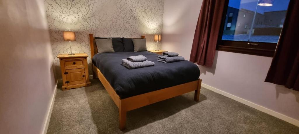 1 dormitorio con 1 cama con 2 toallas en 2 Bed Apt, Westend, recently redecorated, 2 king beds, Close to Ninewells, Fully Equipped, Families, Contractors and Trades, Mid Stays Welcome, en Dundee