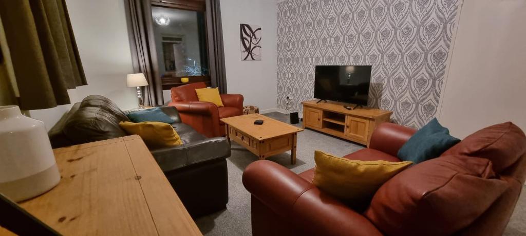 a living room with two couches and a television at 2 Bed Apt, Westend, recently redecorated, 2 king beds, Close to Ninewells, Fully Equipped, Families, Contractors and Trades, Long Stays Welcome in Dundee