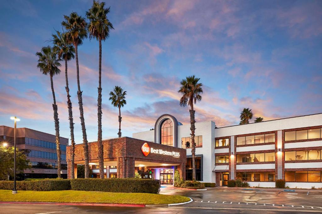 a hotel with palm trees in front of a building at Best Western Plus Meridian Inn & Suites, Anaheim-Orange in Orange