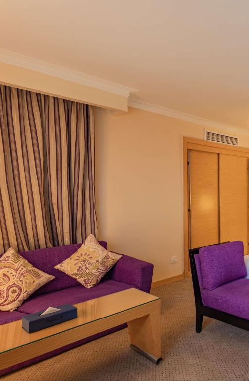 a living room with a purple couch and a chair at Radisson Blu Hotel, Cairo Heliopolis in Cairo