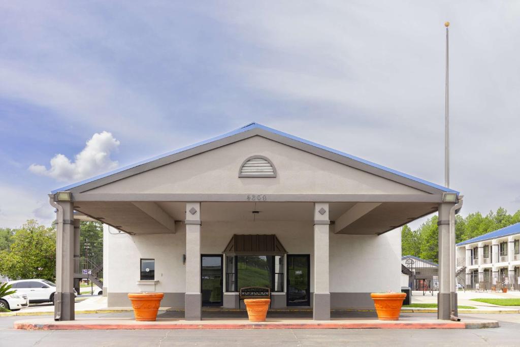 a building with orange pots in front of it at Motel 6 Nacogdoches, TX in Nacogdoches