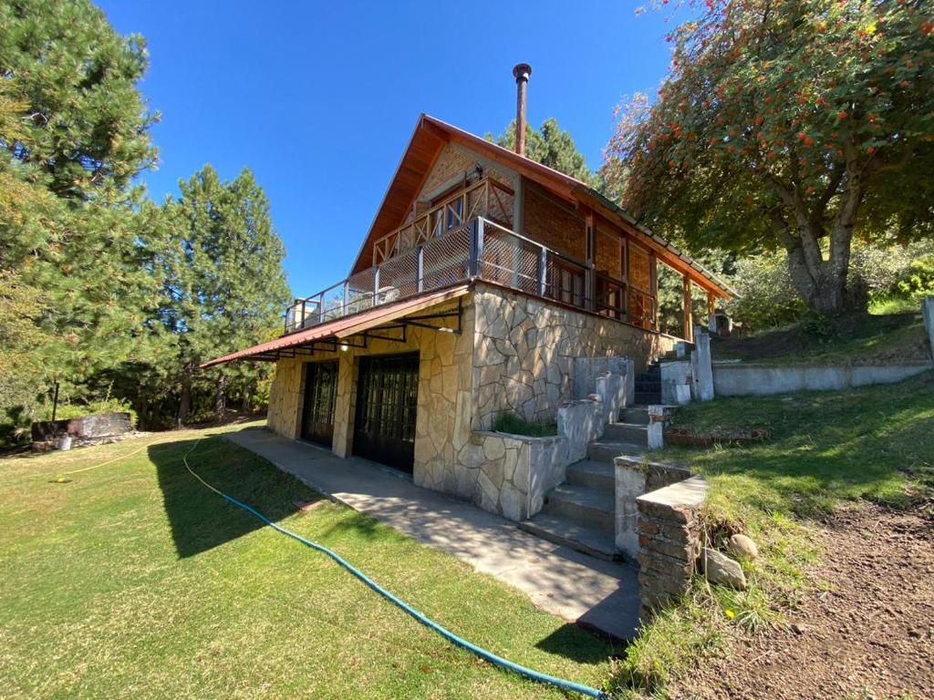 a house with a hose on the grass at CABAÑA EL REMANSO in Villa Pehuenia