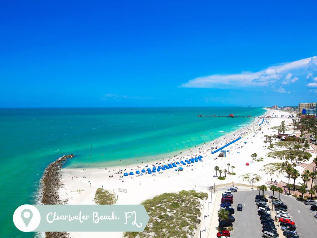 a view of a beach with people and the ocean at Beachcomber Beach House - Weekly Rental Just Steps to White Sand Beach! home in Clearwater Beach
