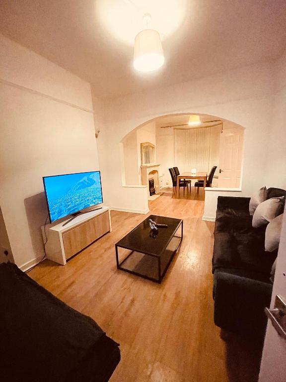 a living room with a couch and a table at 5 STAR BIG SPACIOUS 2 BEDROOM HOUSE, SLEEPS 8, FREE STREET PARKING, EASY ACCESS LOCK BOX ENTRY, 2 minute drive from city centre in Liverpool