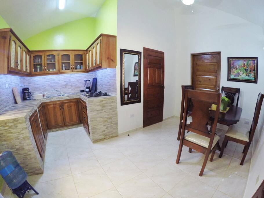 cocina grande con armarios de madera y mesa en Coco Banana Resort Appartment 1 en Las Galeras