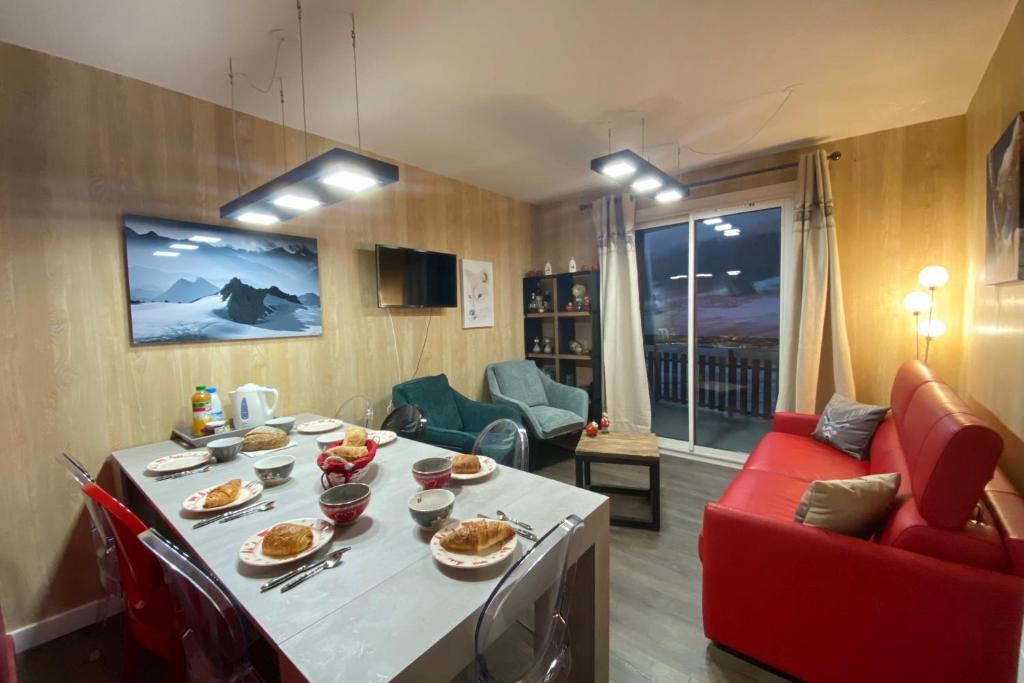una sala de estar con una mesa con comida. en Ski in and ski out apartment Superdévoluy, en Le Dévoluy