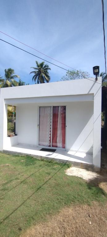 a white building with a window in a yard at Hostal torres del caribe in San Bernardo del Viento