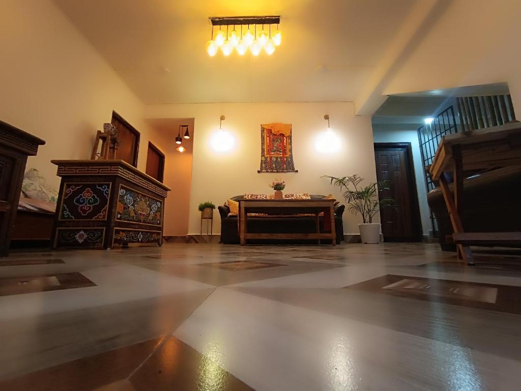 DENZONG HOMESTAY Lhadinkyu في Temi: غرفة معيشة كبيرة مع طاولة وبيانو