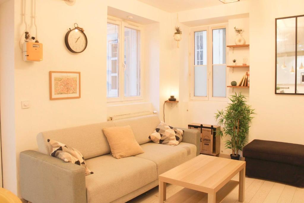 uma sala de estar com um sofá e uma mesa em Cosy 38 m love nest near Centquatre-Paris em Paris