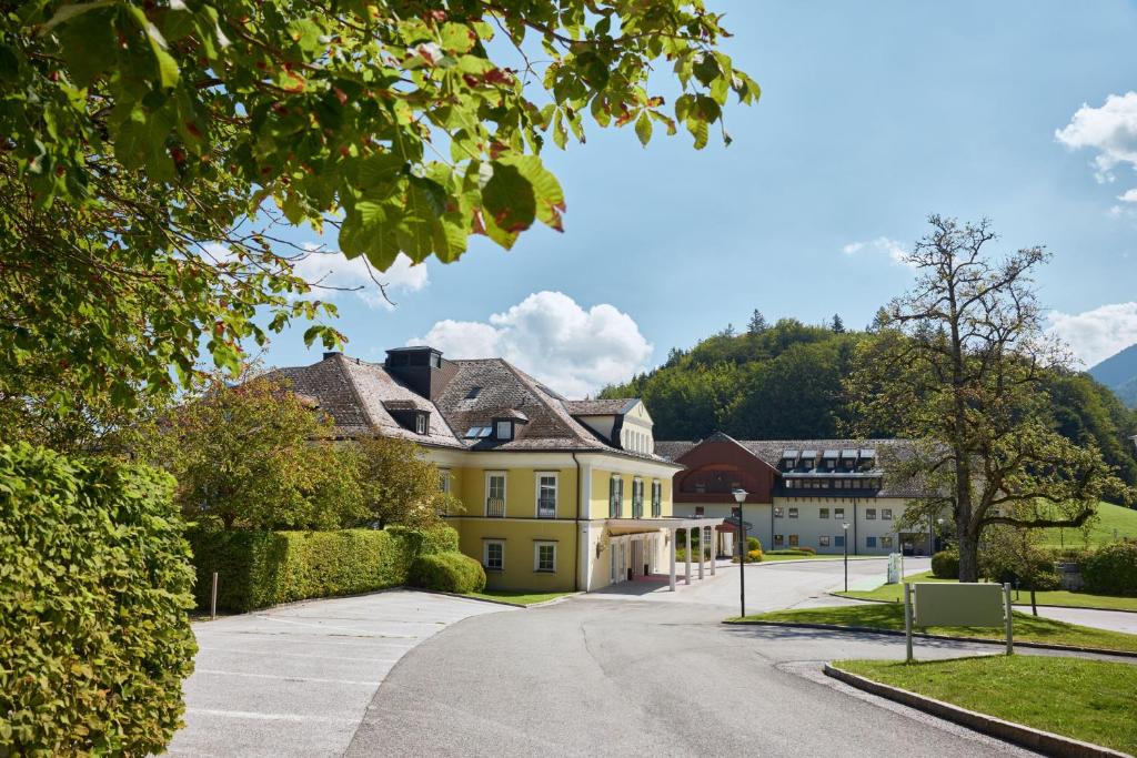 a yellow house in the middle of a street at Arabella Jagdhof Resort am Fuschlsee, a Tribute Portfolio Hotel in Hof bei Salzburg