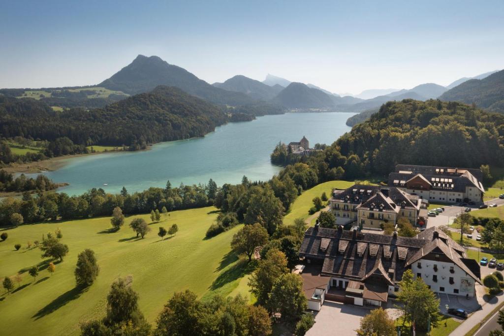 an aerial view of a house on a hill next to a lake at Arabella Jagdhof Resort am Fuschlsee, a Tribute Portfolio Hotel in Hof bei Salzburg