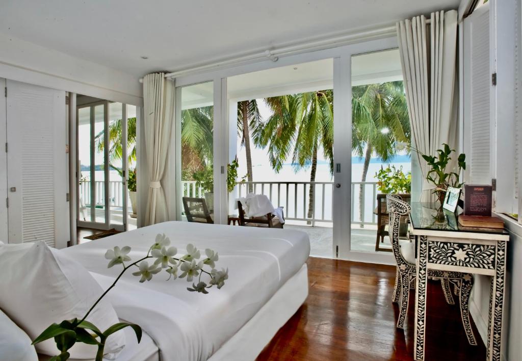 a bedroom with a white bed and a balcony at Villa M in Bophut