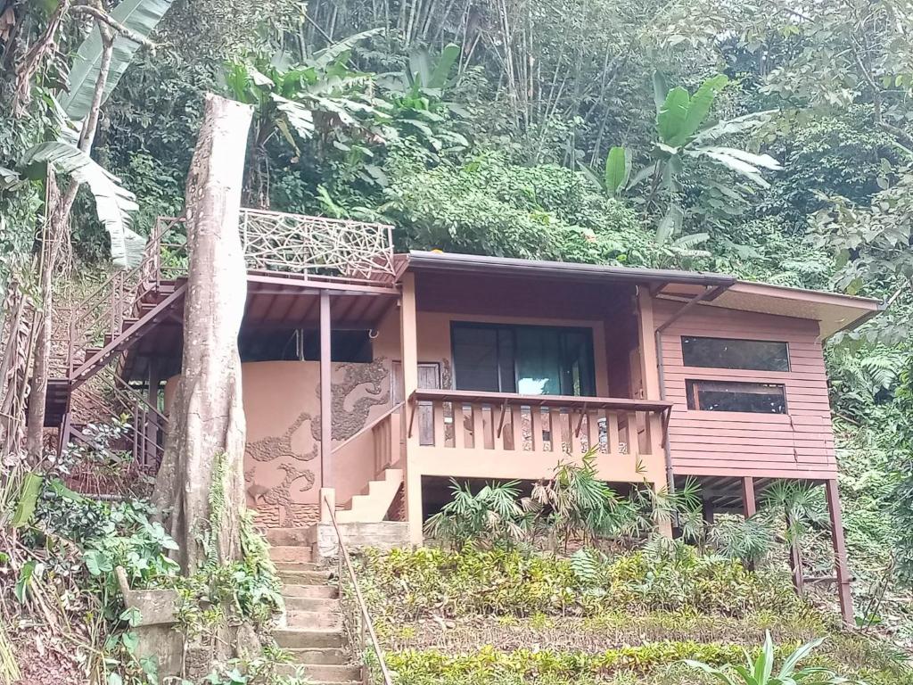 a small house with a balcony in the forest at Eco-Logic, Resort for Charity in Phato