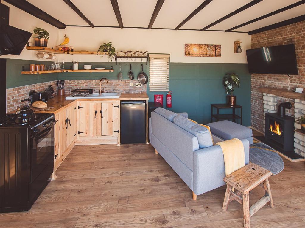 a living room with a couch and a kitchen at Cedar Lodge -uk44425 in Donyatt