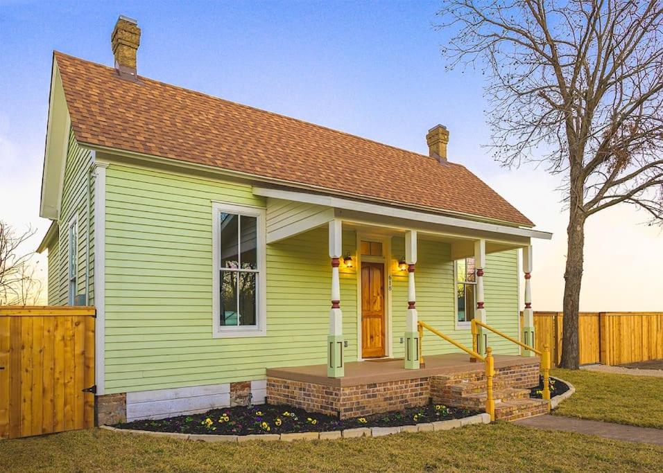 韋科的住宿－The Cahill- Magnolia Brewery House c 1894，一座绿色的小房子,设有黄色的门