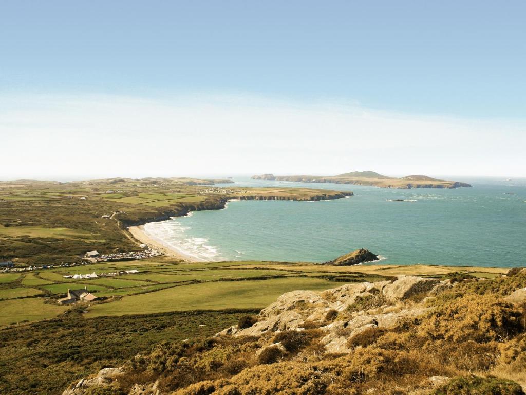 an aerial view of a golf course and the ocean at Ty Gwyn Farmhouse in St. Davids