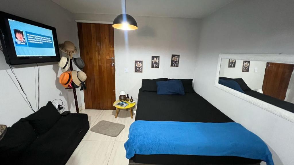 1 dormitorio con 1 cama y TV de pantalla plana en Hospedagem Recanto da Praia Posto 12, en Río de Janeiro