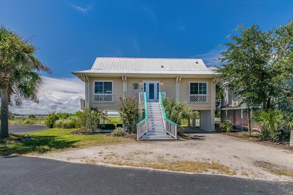 una casa blanca con un porche y una escalera en Seaside Bungalow With Million Dollar Views, en Harbor Island