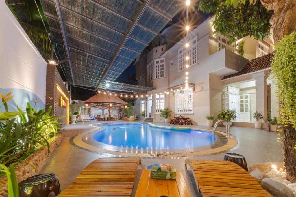 une piscine dans un bâtiment avec des bancs autour dans l'établissement VILLA CHERRY Vung Tau, à Vung Tau
