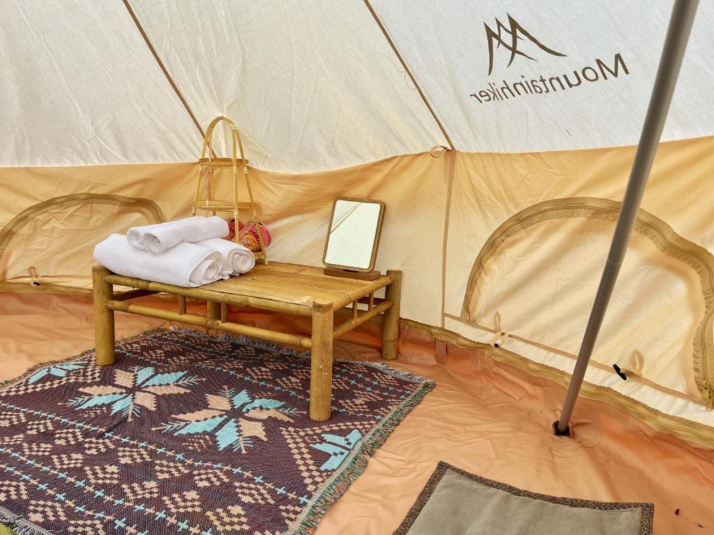 a tent with a mirror and towels on a table at COI NGUON FARM GLAM Mang Den in Kon Von Kla