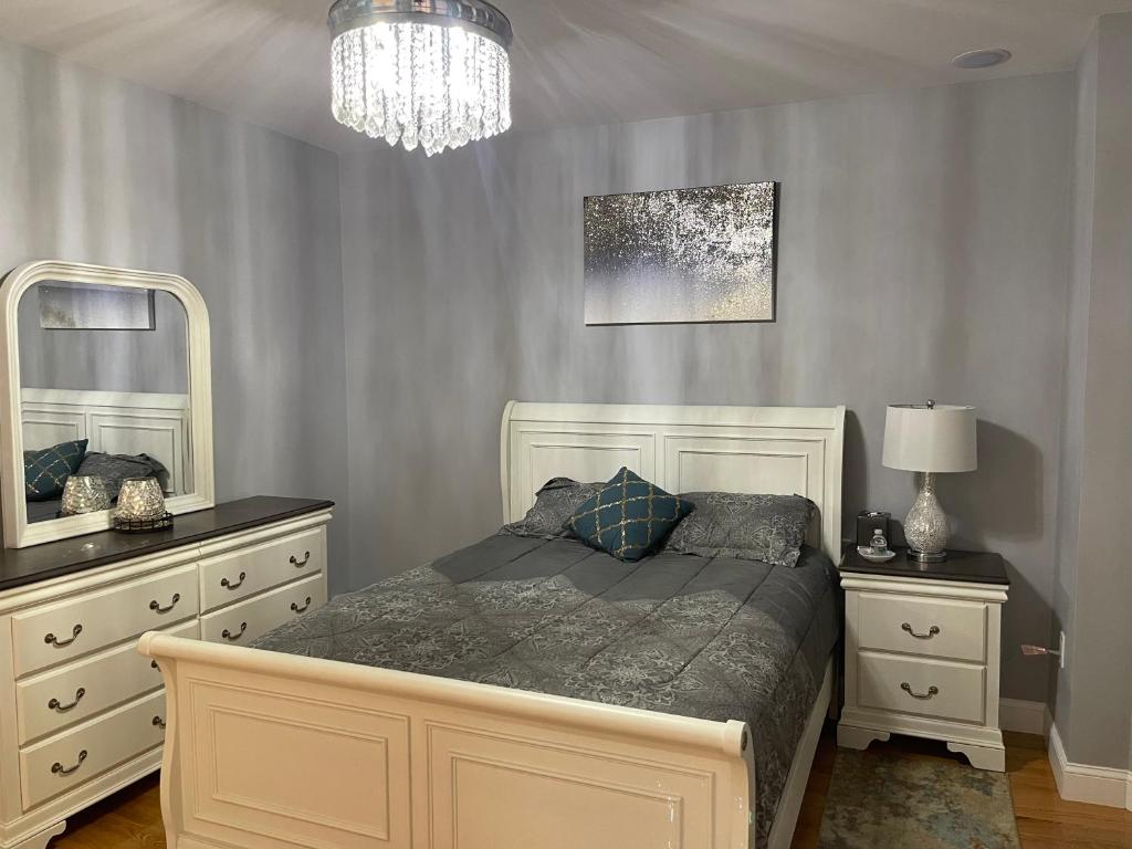 a bedroom with a bed with two dressers and a mirror at Boston Luxury 3 bedroom Private Condo in Boston