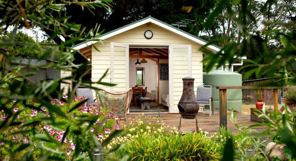 a small white house with a table and chairs at Wanderers Cottage in Woodbridge