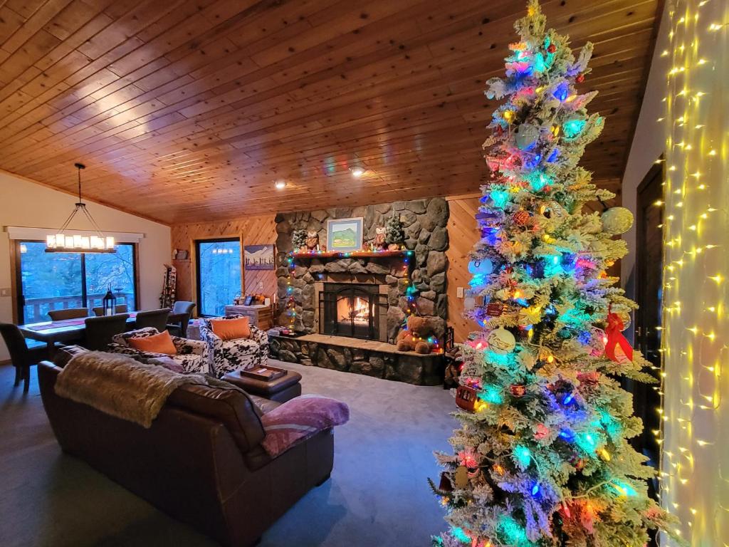 un arbre de Noël dans un salon avec une cheminée dans l'établissement Four Seasons Getaway-Private Hot Spa with Pine Tree Views-Walk to Village and Pineknot Trailhead-Plus King Bed!, à Big Bear Lake