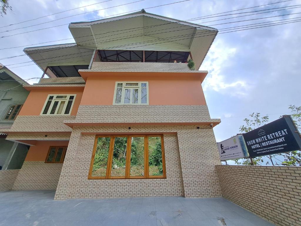 a building with a window on top of it at Snow White Retreat Hotel and Restaurant in Gangtok