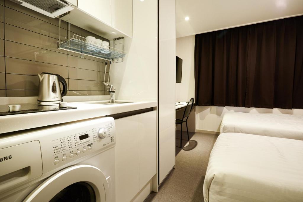 a bathroom with a washing machine in a room at Top Hotel & Residence in Seoul