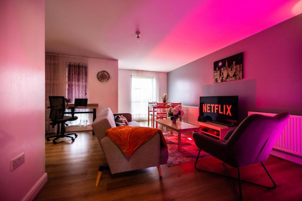 un salon avec des lumières roses sur les murs dans l'établissement Pristine Relocation Pamers Green, à Londres