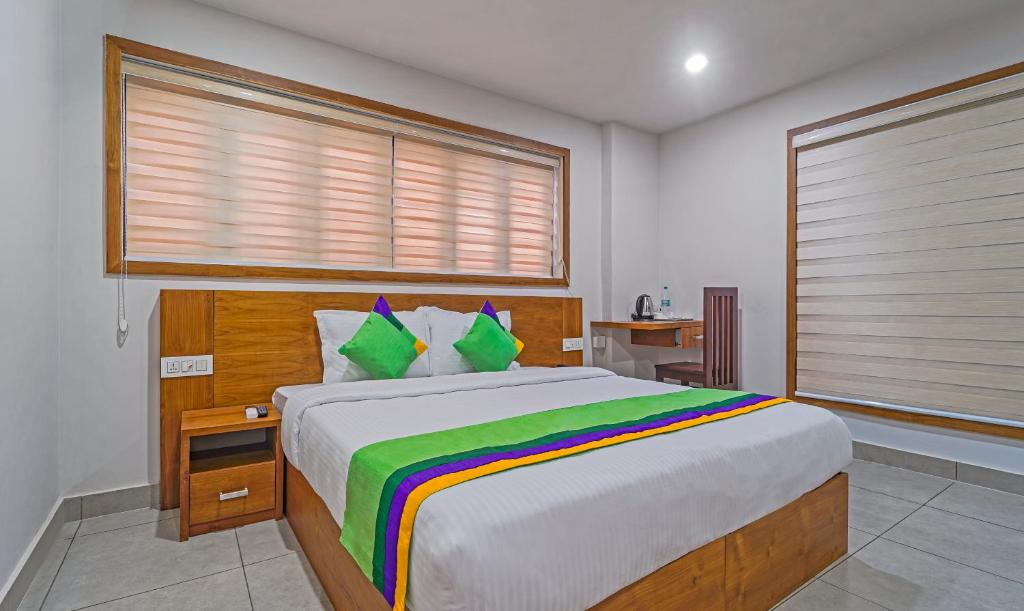 a bedroom with a large bed and a window at Treebo Trend Regalia Inn Civil Station in Kalpetta