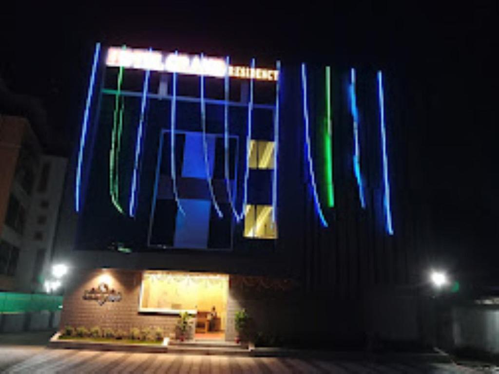 ein Gebäude mit blauer und grüner Beleuchtung in der Nacht in der Unterkunft Hotel Grand Residency , Kolegaon in Dive