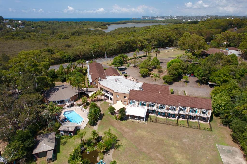 Seaside Garden Retreat Accommodation في Wamberal: اطلالة جوية على بيت كبير مع مسبح