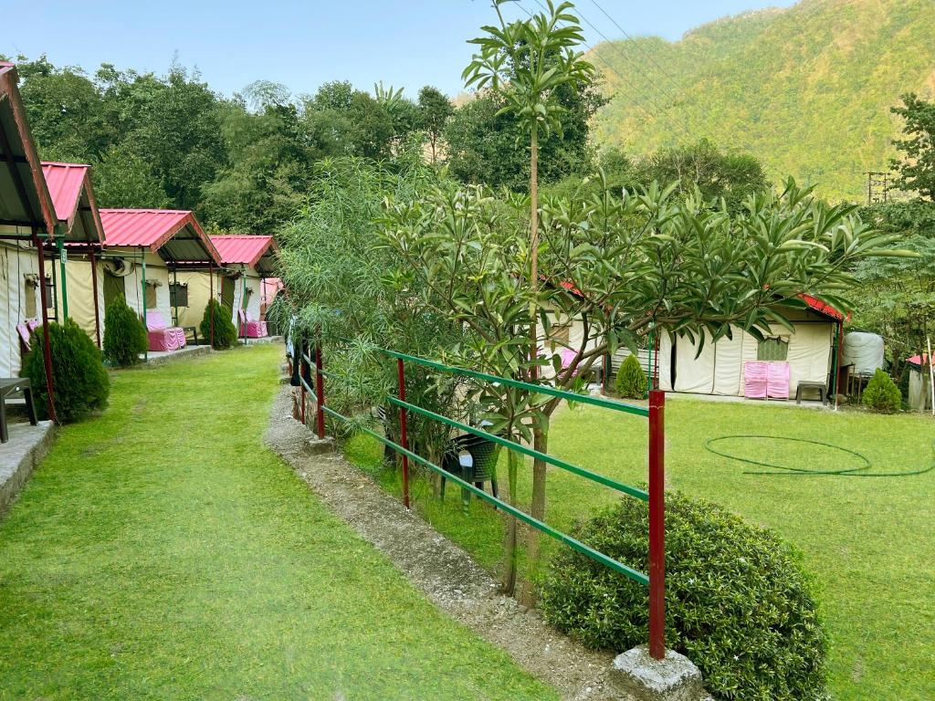 um quintal com cerca, árvores e casas em The Best Memory Camp em Rishikesh