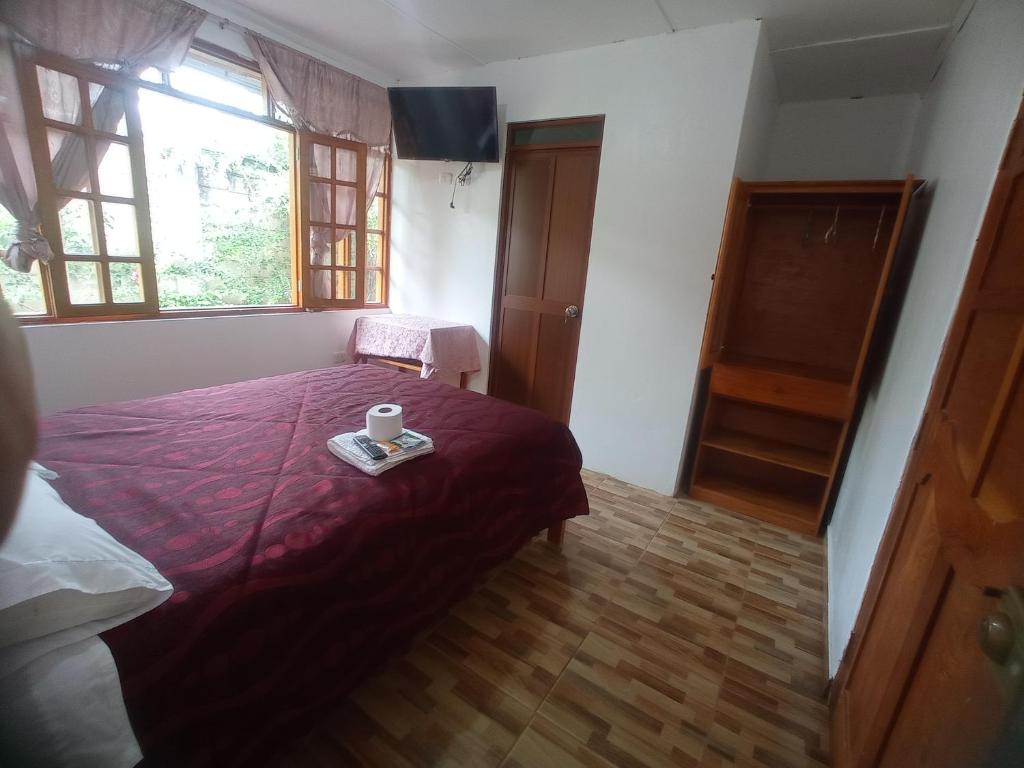 a bedroom with a bed with a tray with a cup on it at Hospedaje Pinky Lodge in Oxapampa