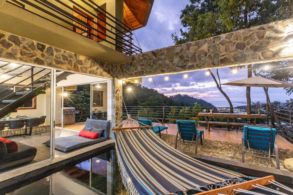 a hammock on the patio of a house at Exclusive Villa Tanager Ocean View w AC Private pool terrace in Quepos