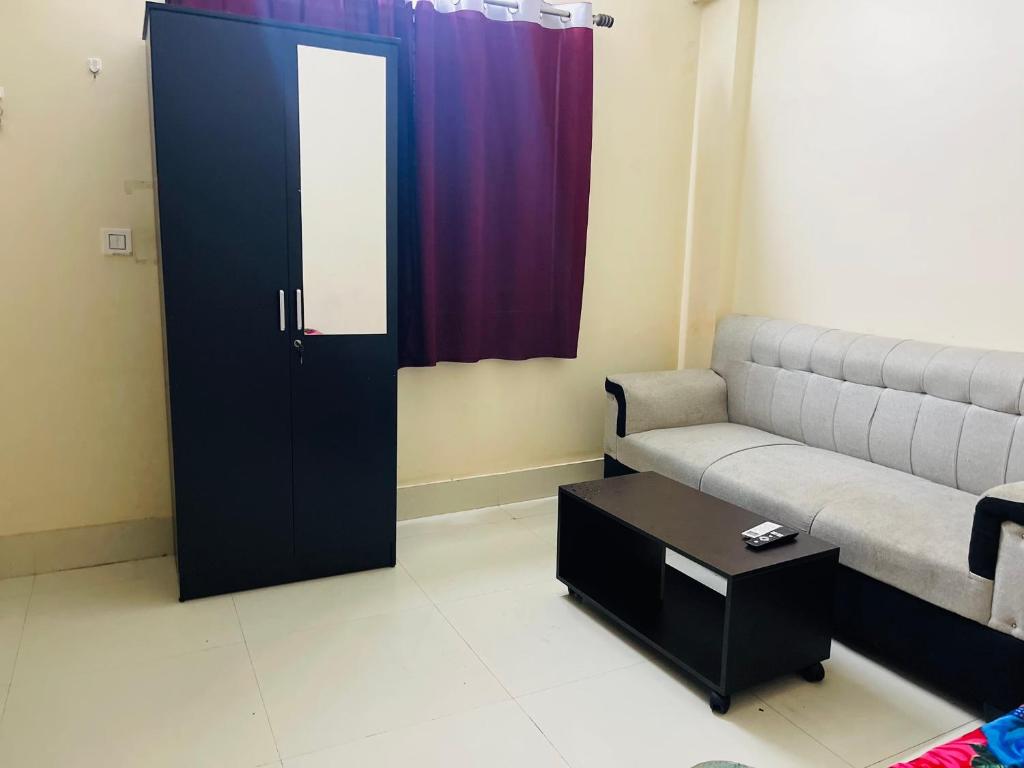 a living room with a couch and a door at Lakeview Apartments Homestay in Agartala