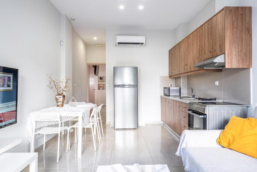 a kitchen and living room with a table and a refrigerator at NEON Apartment, modern, high quality, central Apt, Heraklion City in Heraklio