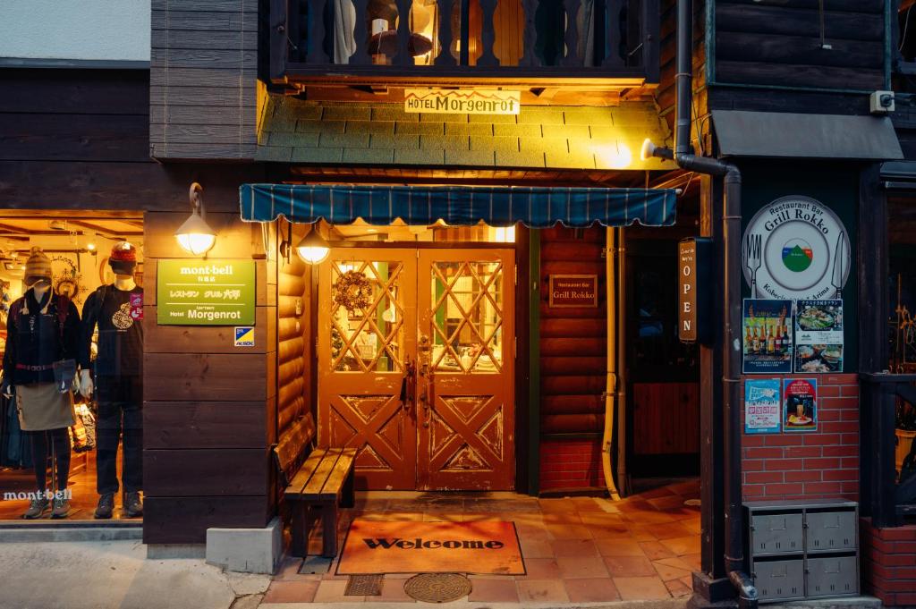 a man standing in front of a store with a door at Hotel Morgenrot in Kobe