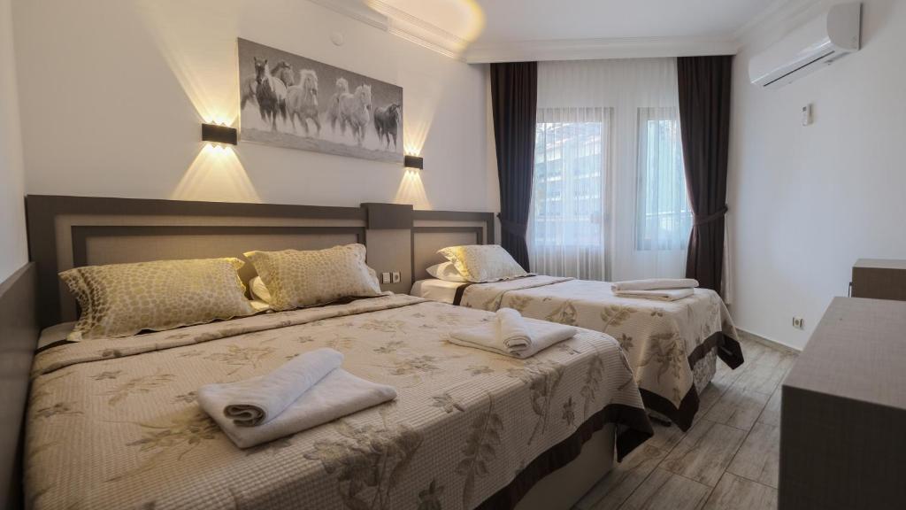 a hotel room with two beds with towels on them at Monte Carlo Hotel in Alanya
