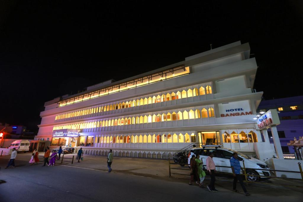 a building with people standing outside of it at night at Hotel Sangam in Kanyakumari