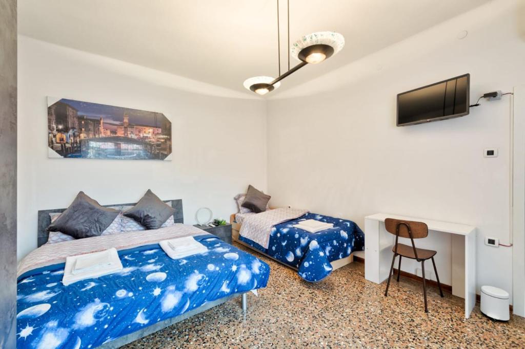 Schlafzimmer mit einem Bett, einem Schreibtisch und einem TV in der Unterkunft City Living Guest House Venice in Mestre