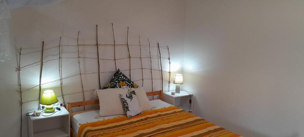 um quarto com uma cama com duas mesas e dois candeeiros em O Logis Coco Le Morne-Rouge, Martinique em Le Morne Rouge