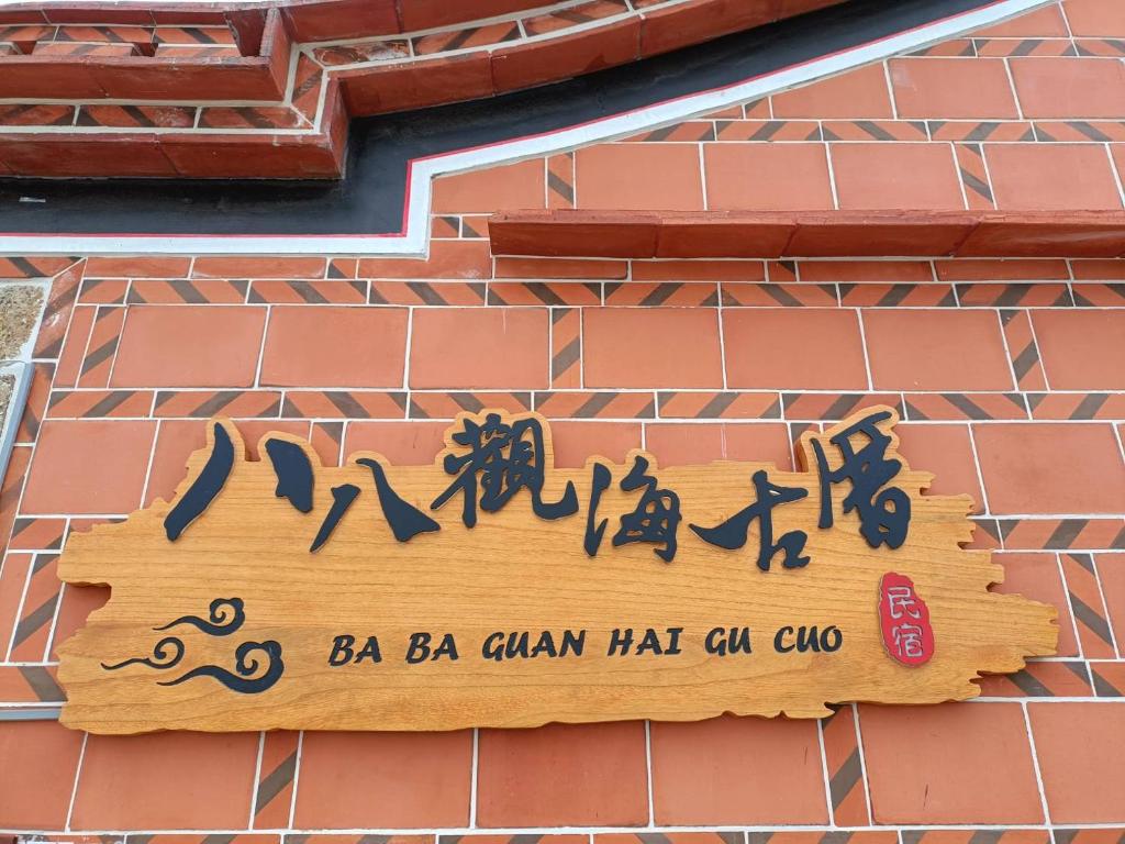 a sign on the side of a brick building at Ba Ba Guan Hai Ancient House B&B in Jinsha