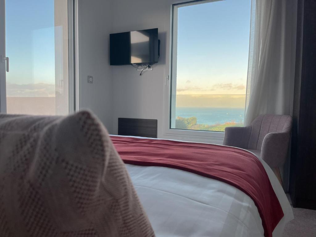 a bedroom with a bed and a large window at LE MANOIR DU ROSELIER HOTEL 3 étoiles in Plérin