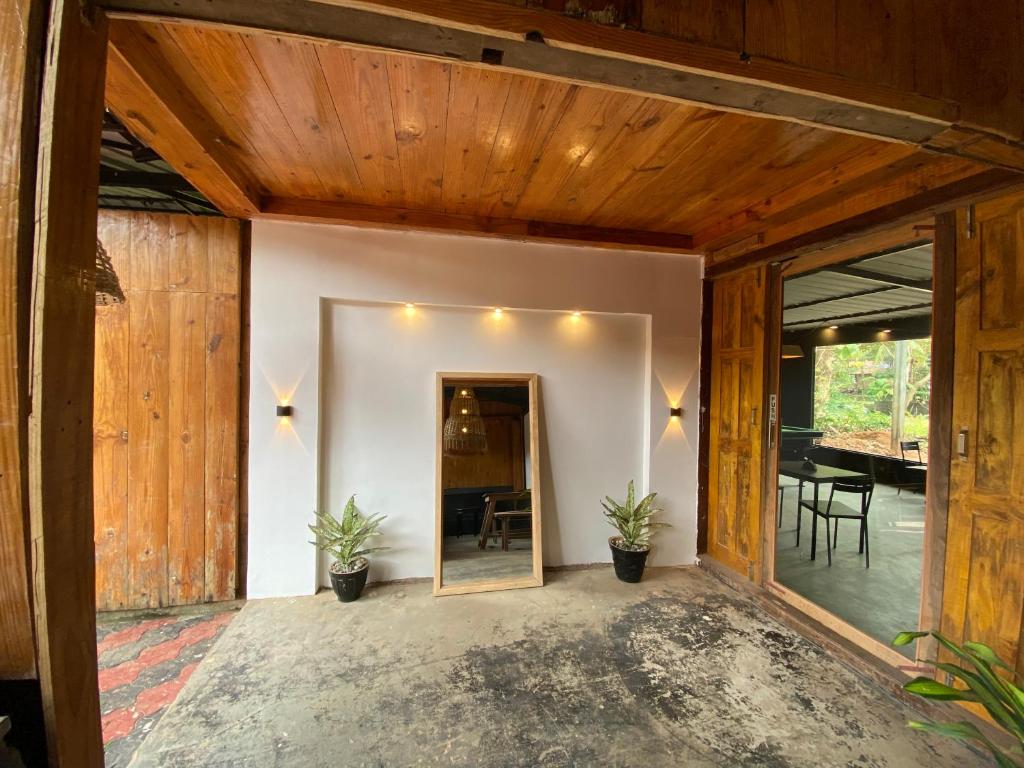 uma sala de estar em plano aberto com paredes de madeira e uma sala de jantar em Bibhitaki Hostels Palolem Beach em Palolem